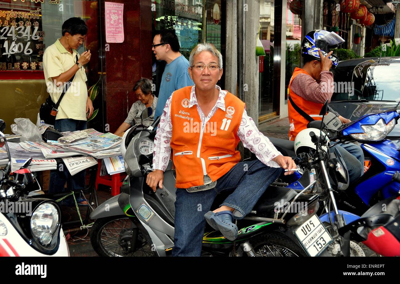 Bangkok, Thailandia: moto taxi driver seduto sulla sua moto in attesa di un passeggero sulla strada Yaoworat a Chinatown Foto Stock