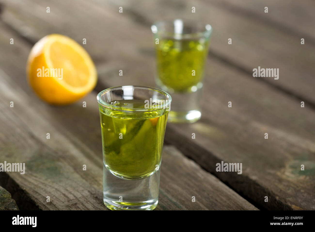 Due bicchierini di liquore di Assenzio Absinthe su uno sfondo di legno Foto Stock