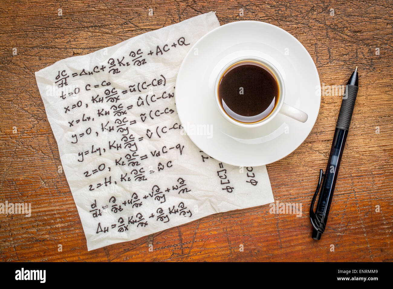 Equazioni matematiche della fisica - scrittura su un tovagliolo con una tazza di caffè su una tavola in legno rustico Foto Stock