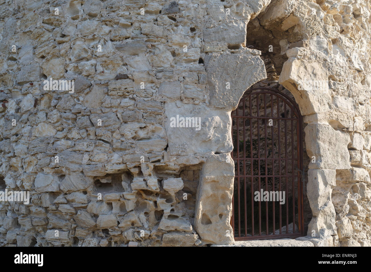 Un grande frammento del vecchio retrò muro di pietra con metallo arrugginito griglia. Foto Stock