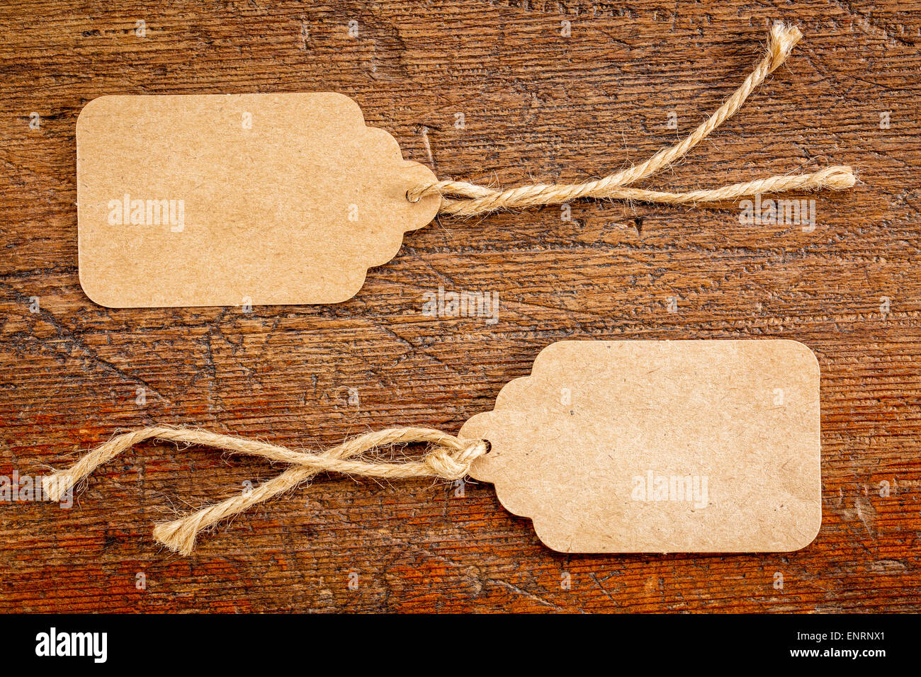 Due fogli di carta bianca i cartellini dei prezzi con lo spago contro rustico di legno graffiato Foto Stock