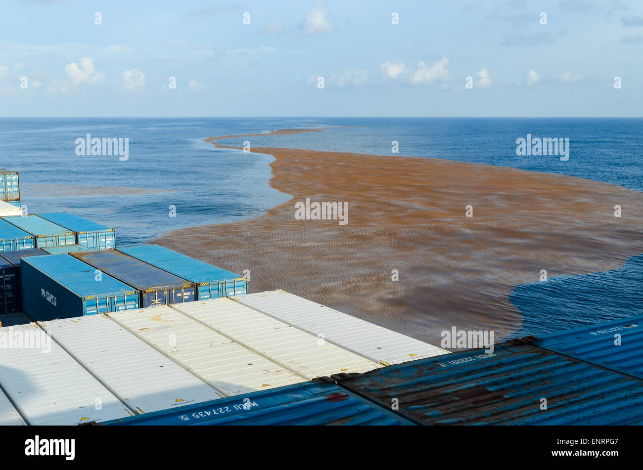 Contenitore nave che naviga nell Oceano Atlantico attraverso rifiuti galleggianti sulla superficie dell'acqua Foto Stock