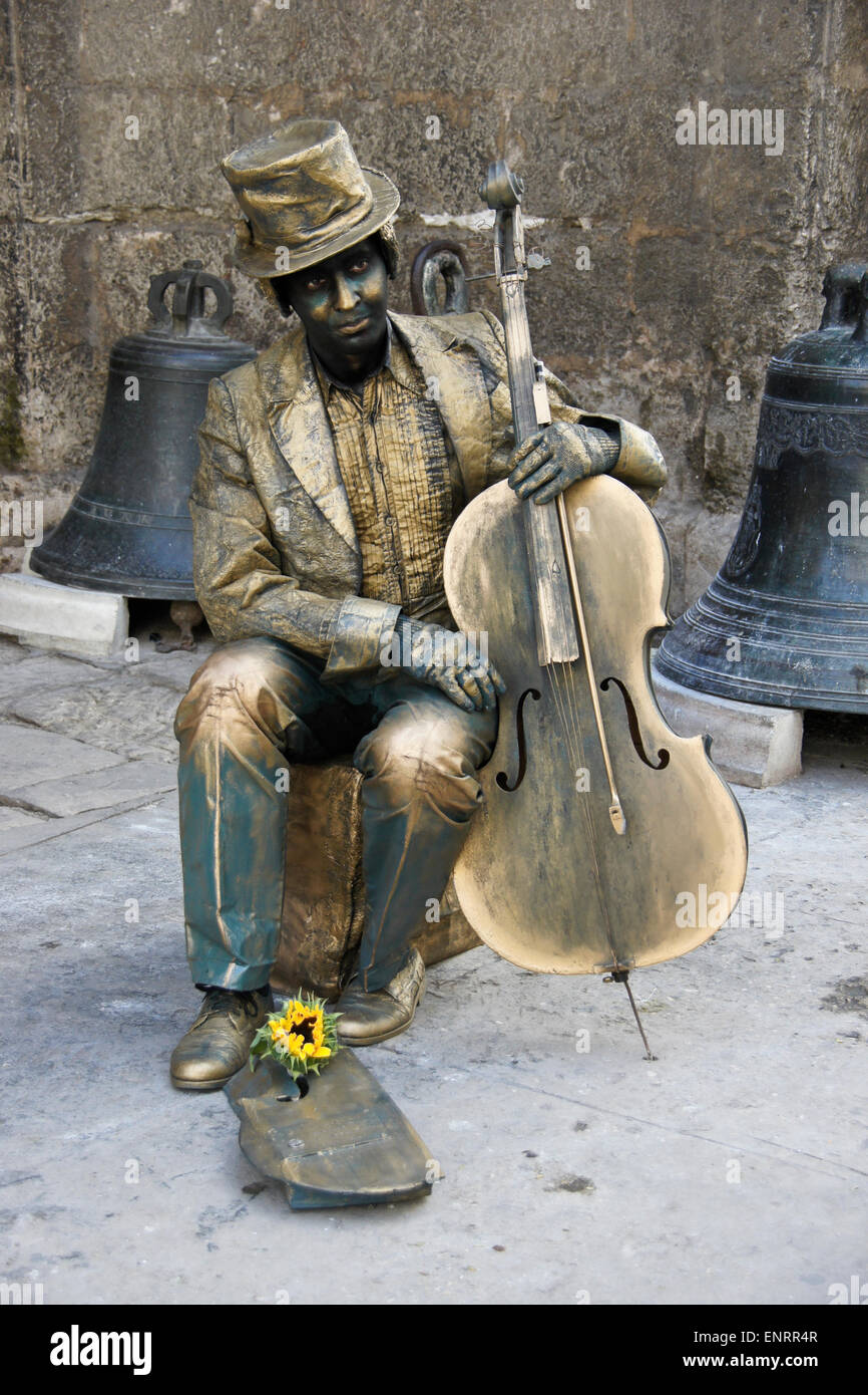 Street performer vestito come statua in bronzo con violoncello, al di fuori della chiesa di San Francisco de Asis, Habana Vieja (l'Avana Vecchia), Cuba Foto Stock