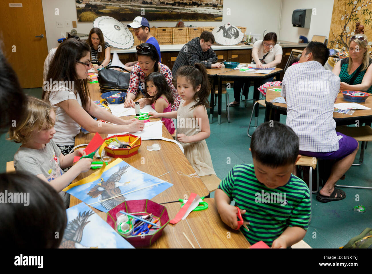 Bambini e genitori rendendo aquiloni asiatici - USA Foto Stock