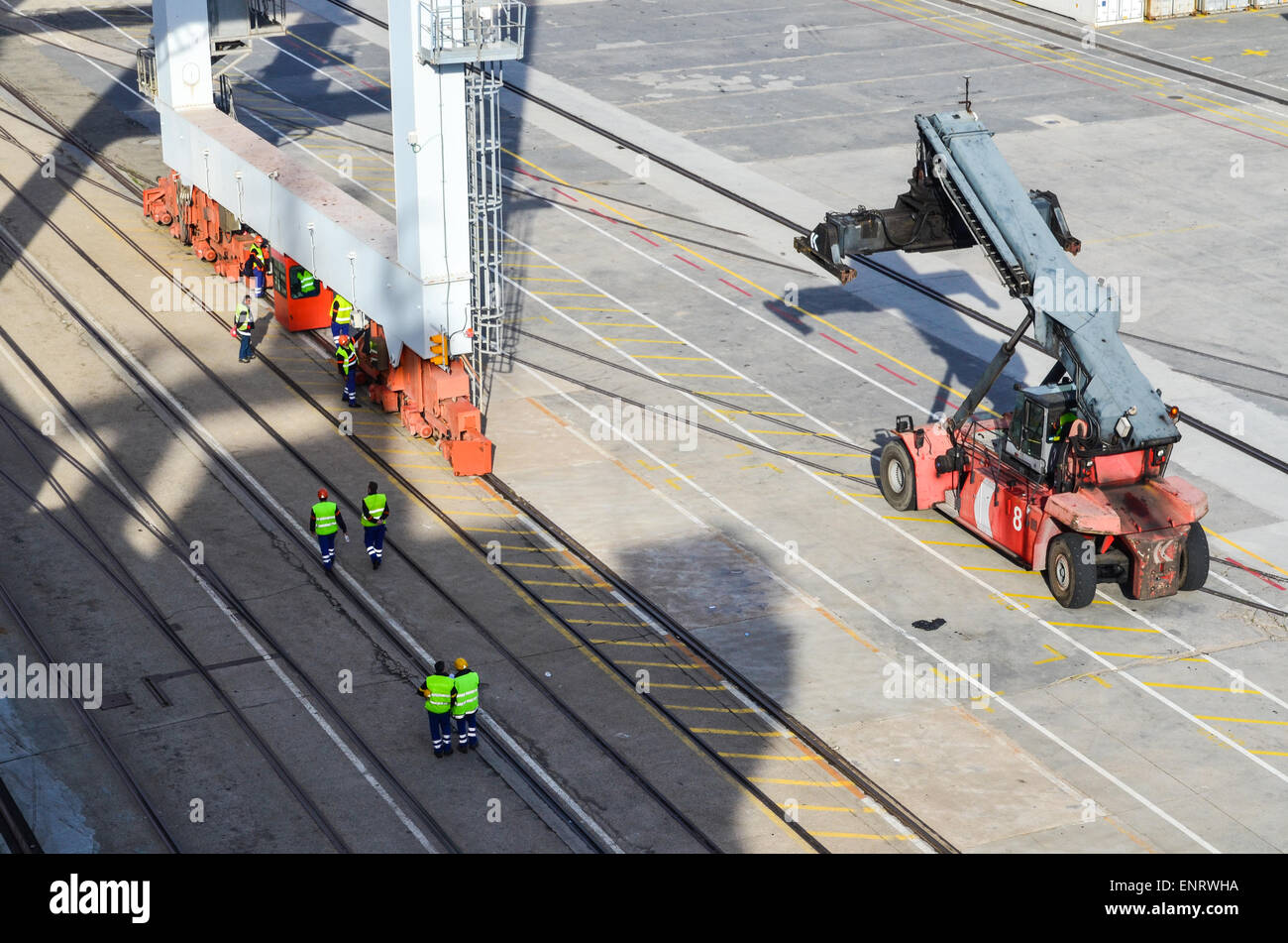 I lavoratori e la movimentazione del carico sui carrelli elevatori presso il terminal per container del porto di Vigo, Spagna Foto Stock