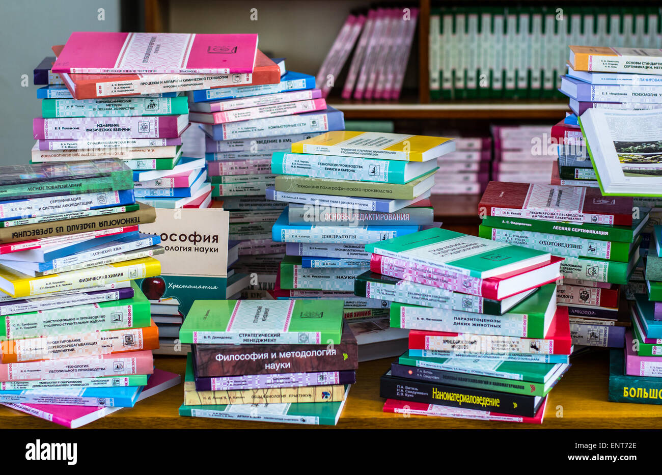 Una ragazza sono trasportano informazioni sulle pile di libri e chiedendo circa i buoni contrassegni Foto Stock