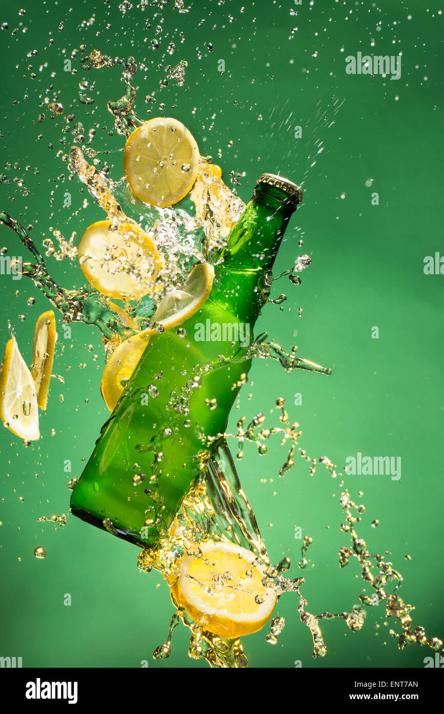 Verde bottiglia di birra con gli spruzzi di liquido, congelare il movimento. Foto Stock