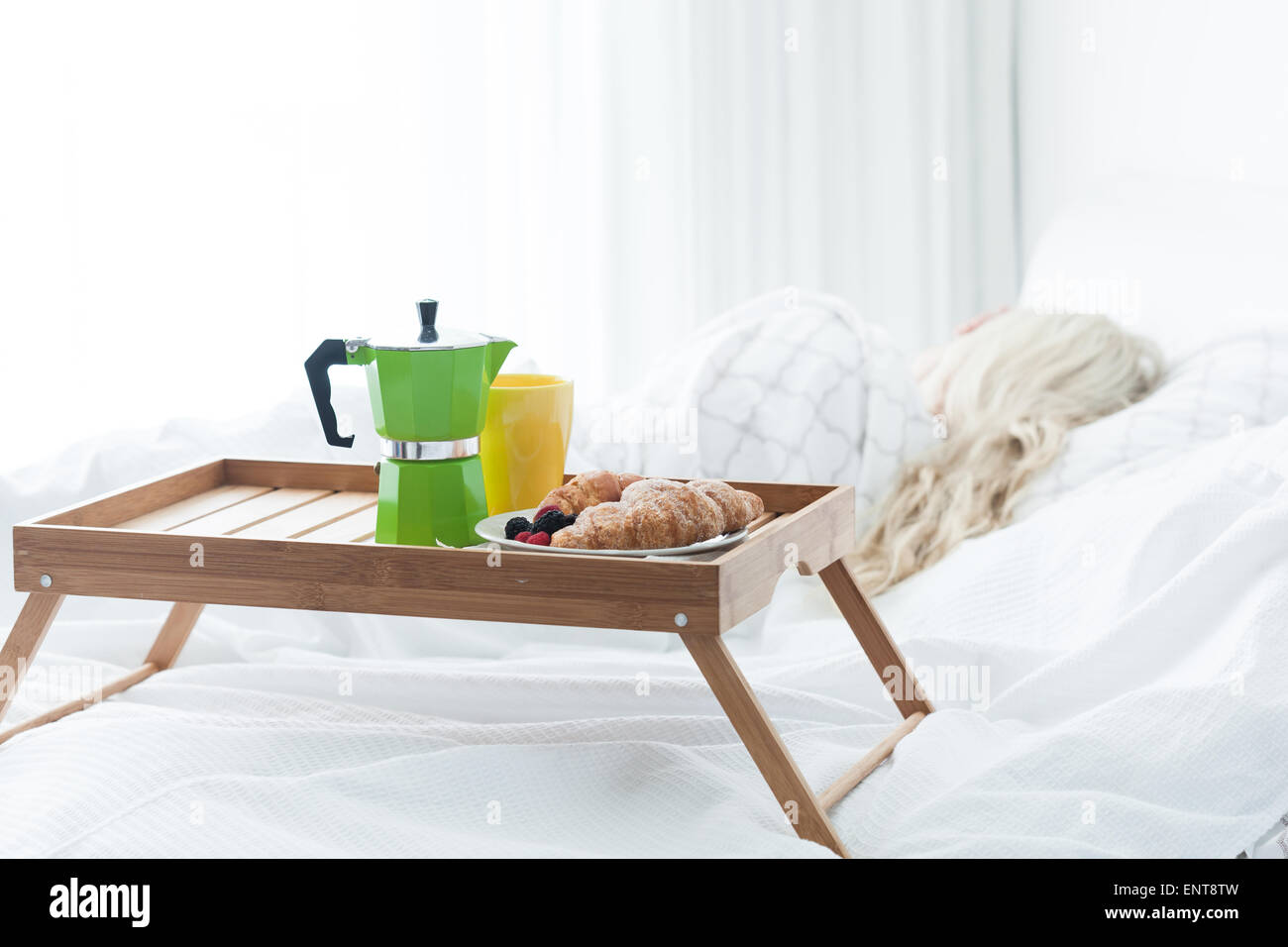 Colazione vassoio in legno con caffettiera e croissant sul letto Foto Stock