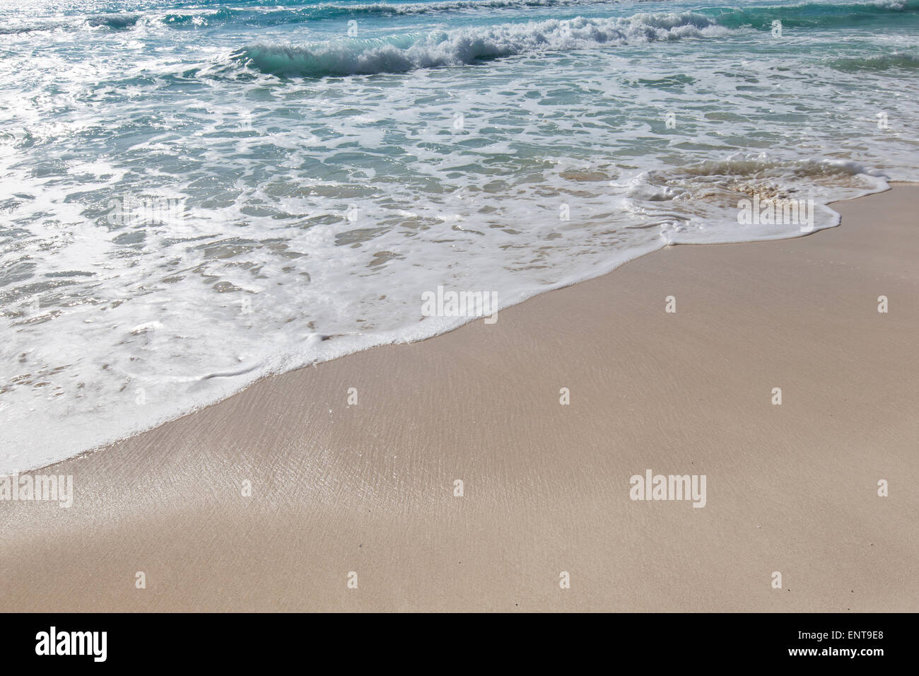 Le onde del mare con la schiuma sulla bianca spiaggia sabbiosa tropicale Foto Stock