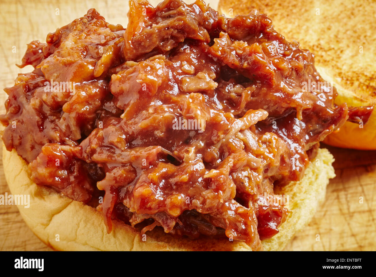 Estratto di carne di maiale, una tradizione del cibo dal sud degli Stati Uniti. È servita qui su un hamburger bun, un comune modo di mangiare oggi. Foto Stock