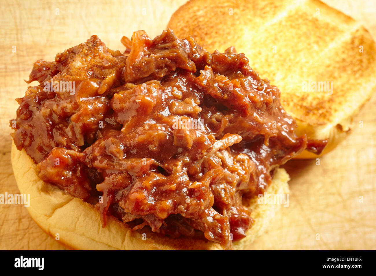 Estratto di carne di maiale, una tradizione del cibo dal sud degli Stati Uniti. È servita qui su un hamburger bun, un comune modo di mangiare oggi. Foto Stock