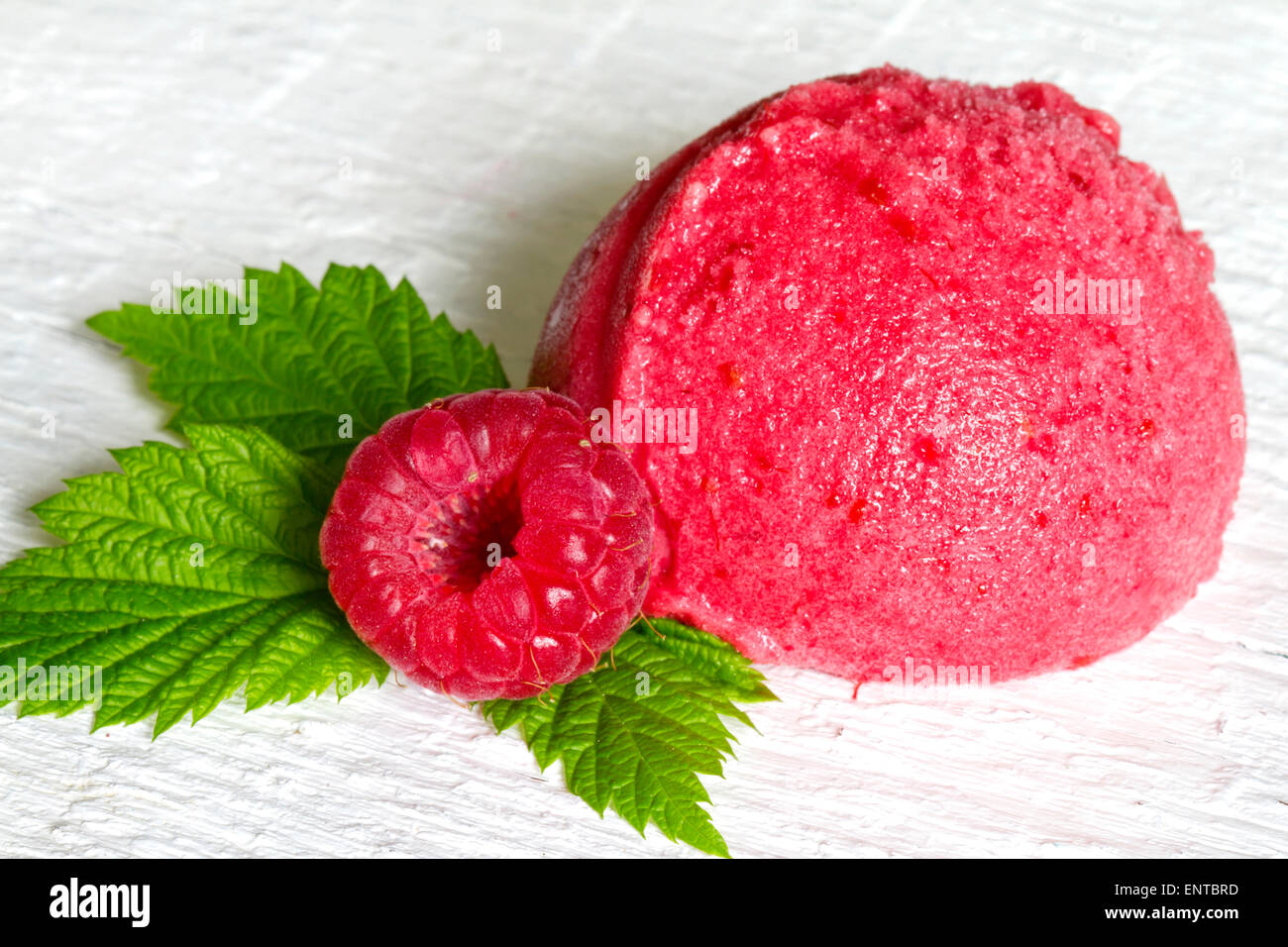 Convogliatore del gelato al lampone con frutta fresca e foglia verde closeup Foto Stock