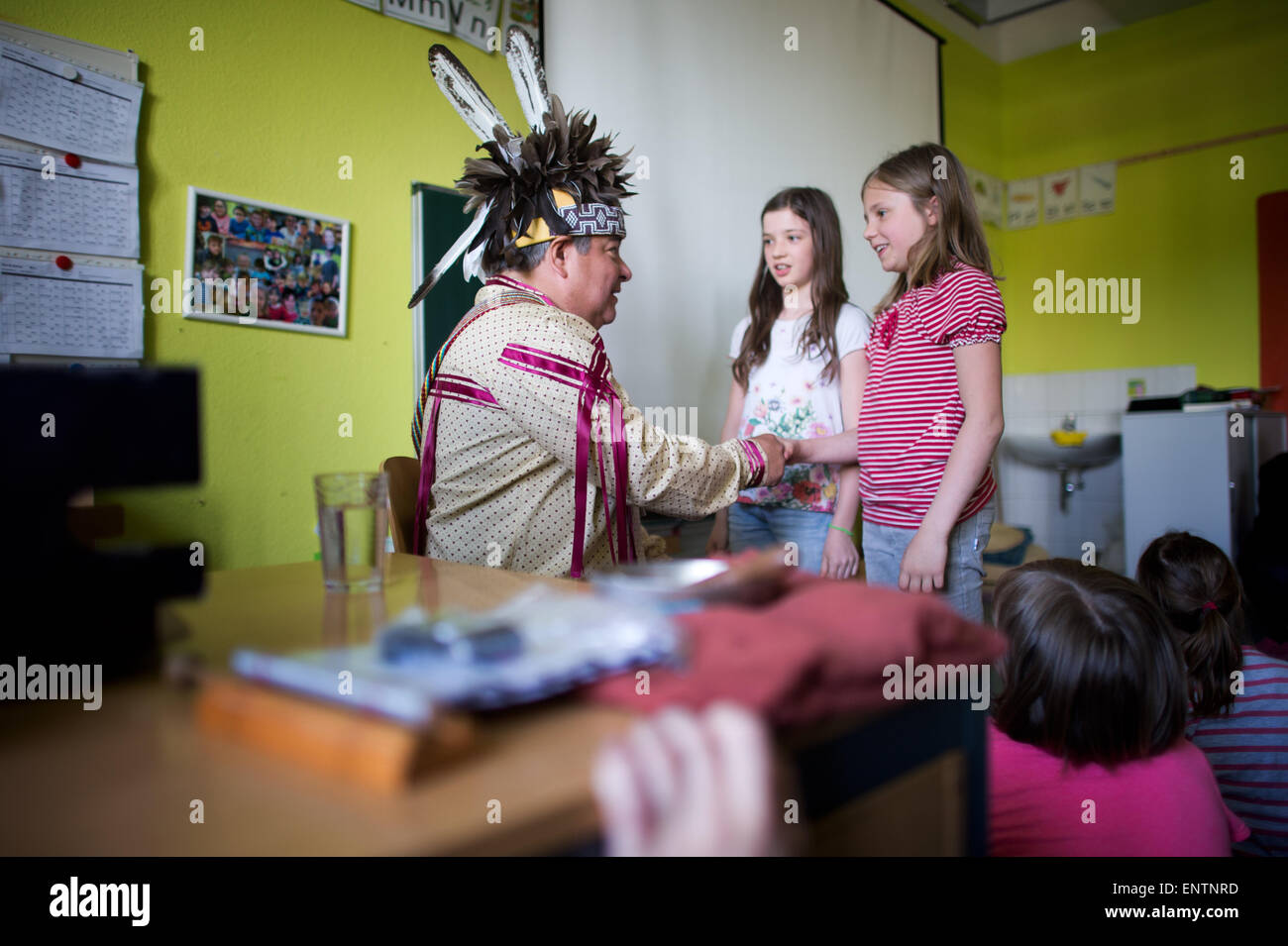 Radebeul, Germania. 11 Maggio, 2015. Dale Rood, Turtle capo clan rappresentante del Oneida nazione indiana, parla a un gruppo di grado 3 e 4 studenti della Evangelische Grundschule (Luterana scuola primaria) prima di Karl Festival di maggio a Radebeul, Germania, 11 maggio 2015. Egli ha illustrato la vita dei nativi Indiani americani nel nord moderna società americana da mostrare i film e raccontare storie. Foto: ARNO BURGI/dpa/Alamy Live News Foto Stock