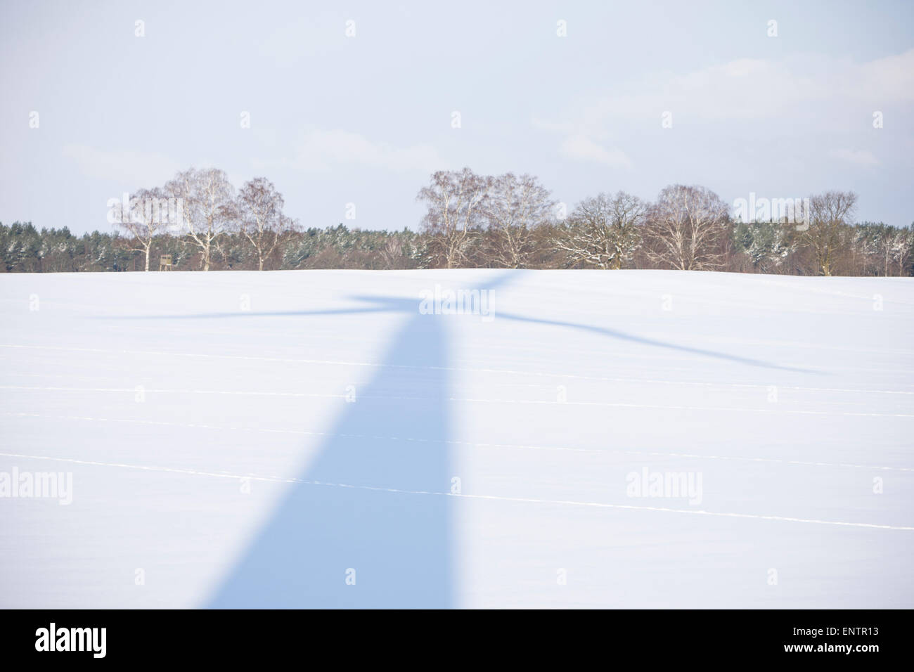 Una turbina eolica ombra sulle nevi di un campo vicino Goscino, Polonia. Foto Stock