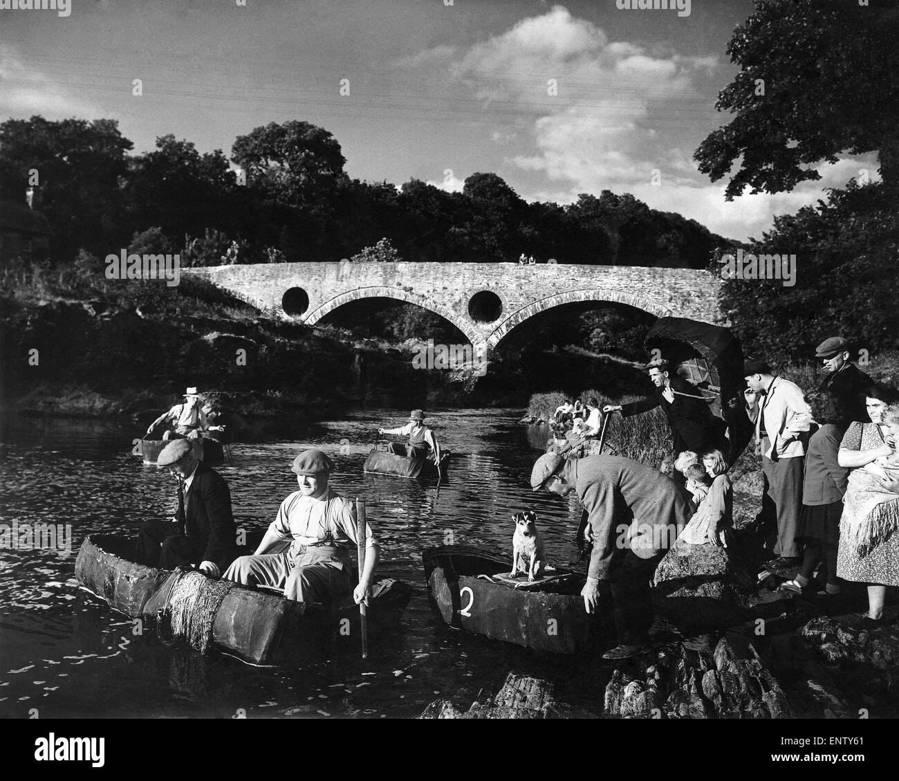 Dal famoso ponte Cenarth il coracle pescatori stabiliti per una giornata di pesca. Essi lavorano a coppie e ogni coppia deve mantenere almeno duecento metri dall'altro. Spesso il womenfolk e i bambini venuti a vedere loro fuori - augurare loro buone catture. Circa 1945 Foto Stock