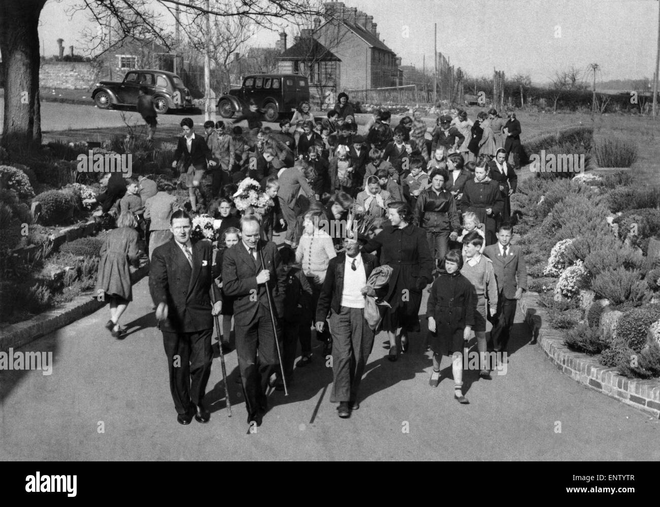 Seguita da ragazzi locali i tutti gli uomini esposti a pagare le loro chiamate per una moneta o un bacio a Hungerford. 19 Aprile 1955 Foto Stock