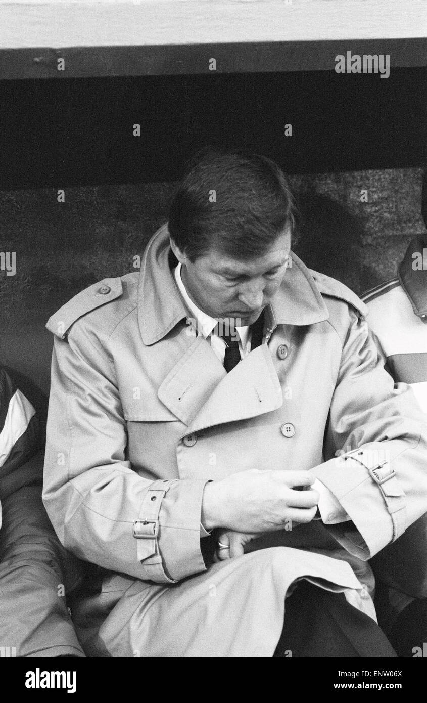 Il Manchester United manager Alex Ferguson controlla il suo orologio in piroga durante la divisione lega una partita contro il Charlton Athletic presso la valle di massa. La partita si è conclusa in un goalless draw. 7 febbraio 1987. Foto Stock