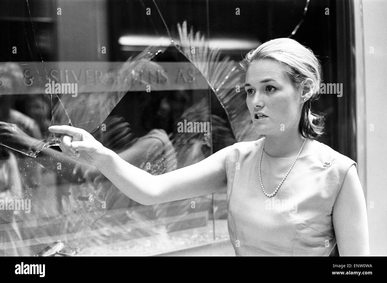 Burlington Arcade rapina, Piccadilly, Londra, 27 giugno 1964. Avvisatore acustico rimbombava e fari anteriori su una Jaguar ruggito fino ad un negozio di Gioielleria in una zona pedonale arcade. Fuori della vettura saltò cinque uomini mascherati con mazza e barre di ferro. E come gli acquirenti dispersi i banditi fracassato in windows e sono scappati con diamante anelli e bracciali che vale la pena di £ 50.000, dai gioiellieri di proprietà di orafi e argentieri' Association. Nella foto: shop assistant Cherry-Anne Watson, 21, di Earls Court di Londra. Foto Stock