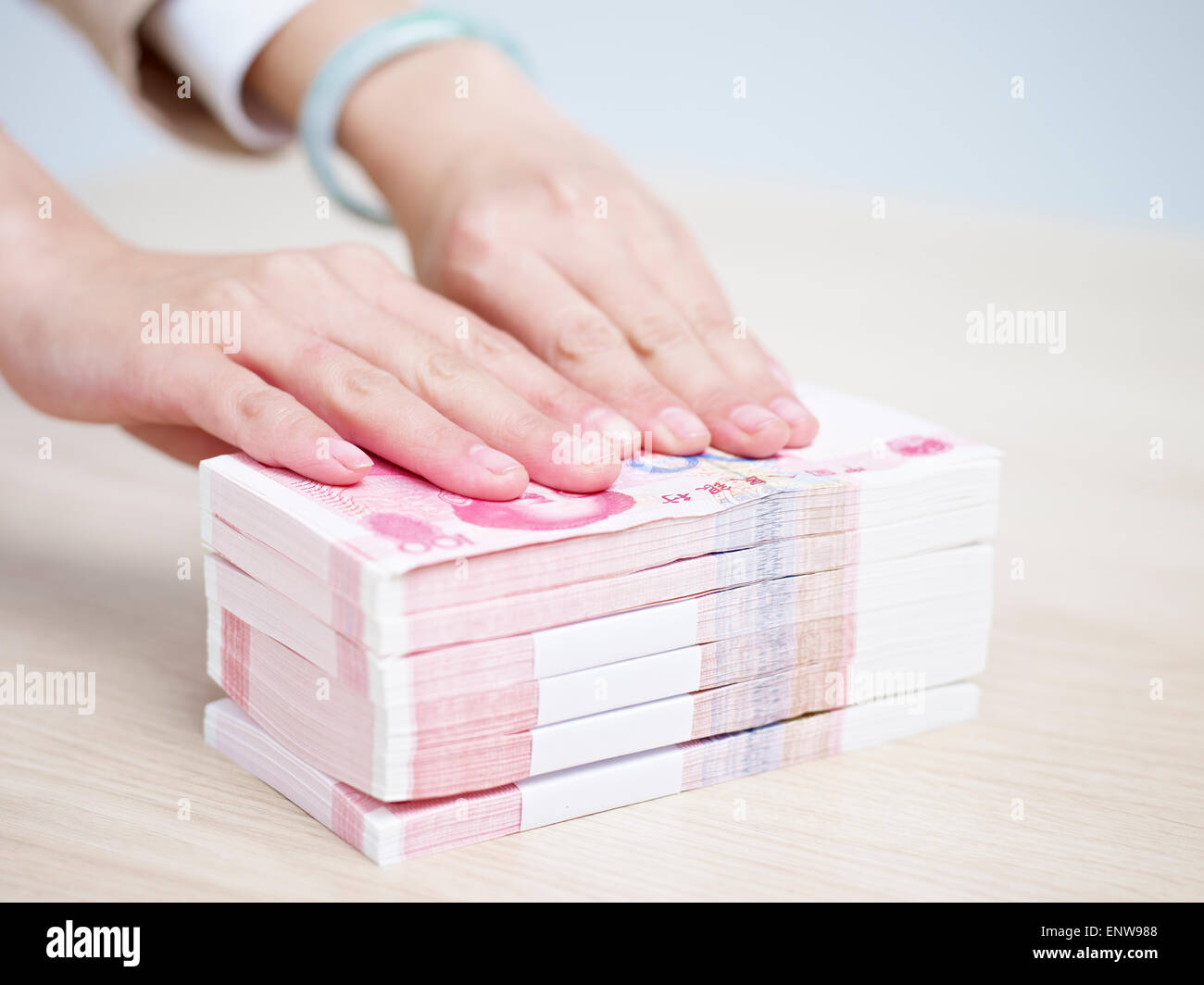 La mano di una donna di spingere in avanti la risma di denaro cinese Foto Stock