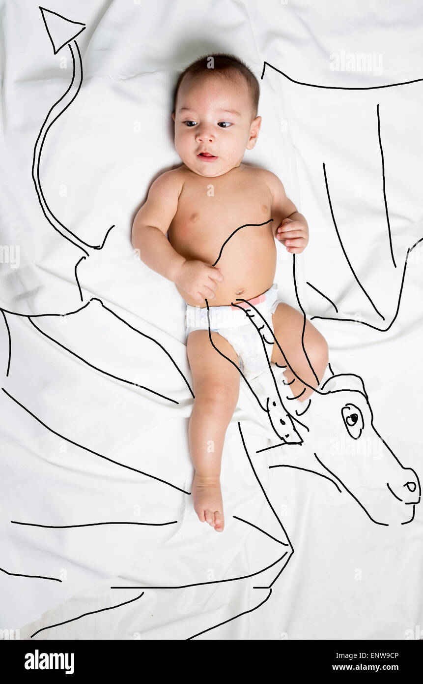 Carino baby boy decorate a cavallo di un drago Foto Stock