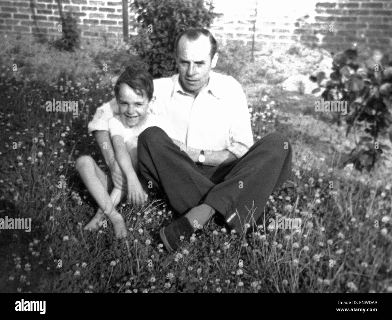 Negli anni cinquanta, Famiglia, padre e figlio seduti su un prato, embracement, uomo 35-45 anni, bambino, ragazzo da 4 a 6 anni, Werner, Josef Foto Stock