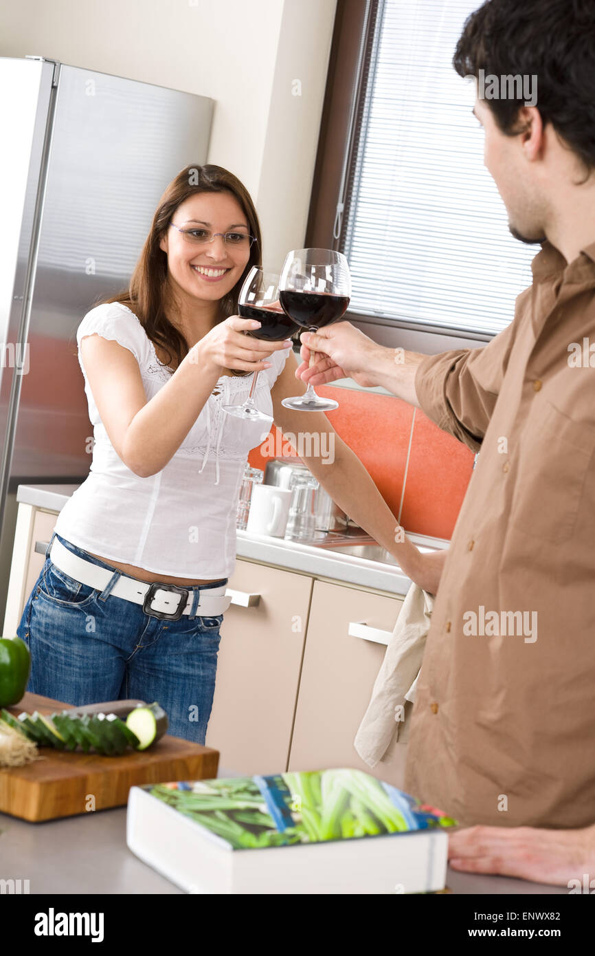 Coppia giovane la tostatura con vino rosso in cucina Foto Stock