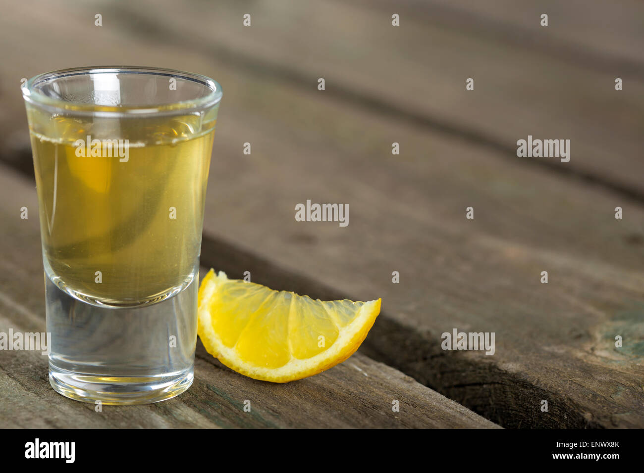 Tequila shot con limone sul legno scuro dello sfondo con spazio di copia Foto Stock