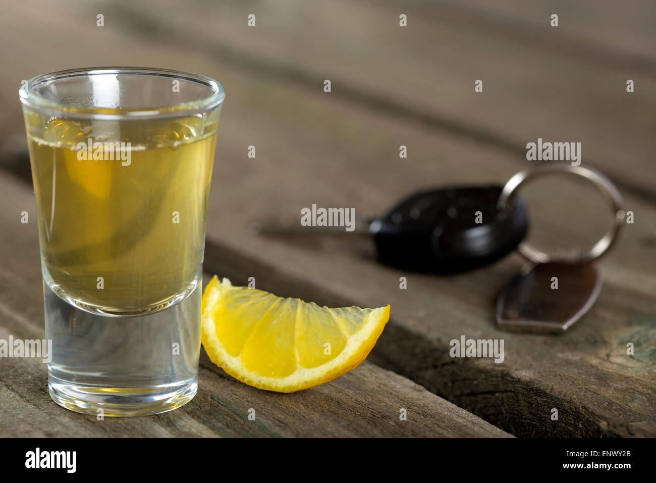 Tequila shot con limone sul legno scuro dello sfondo con una chiave auto Foto Stock