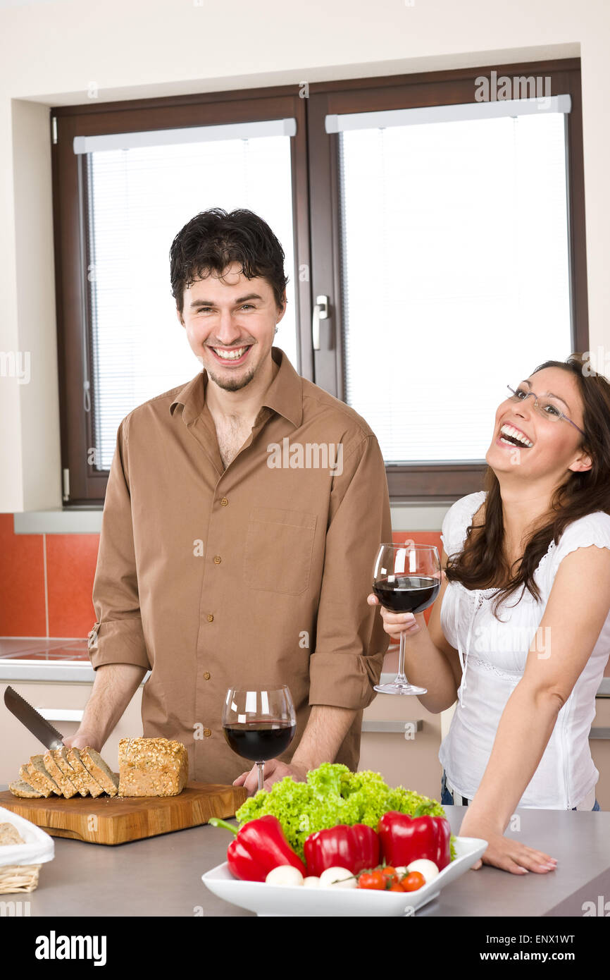 Coppia felice nella cucina moderna bere vino rosso Foto Stock