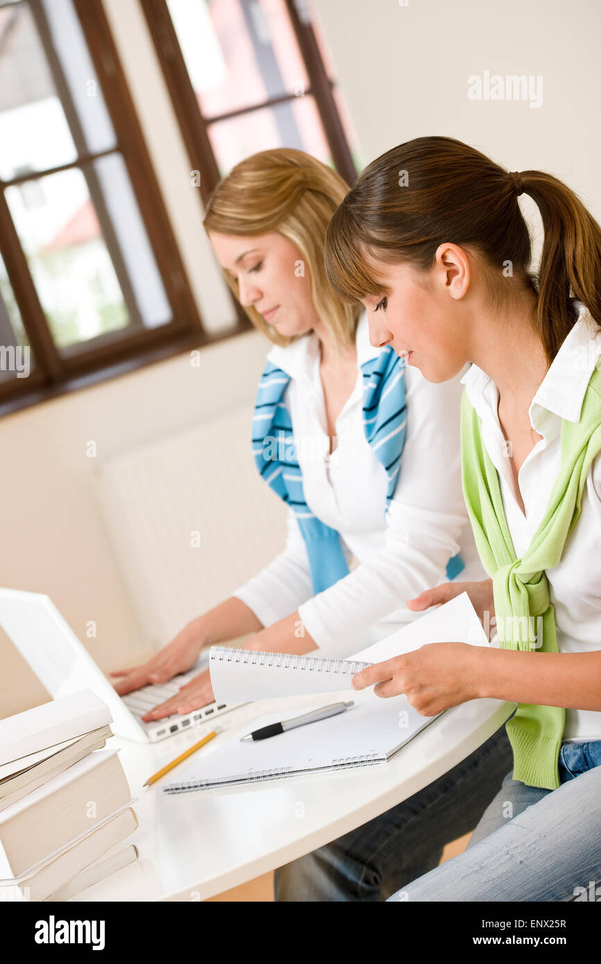 Studente a casa - due donna con libro e il computer portatile Foto Stock