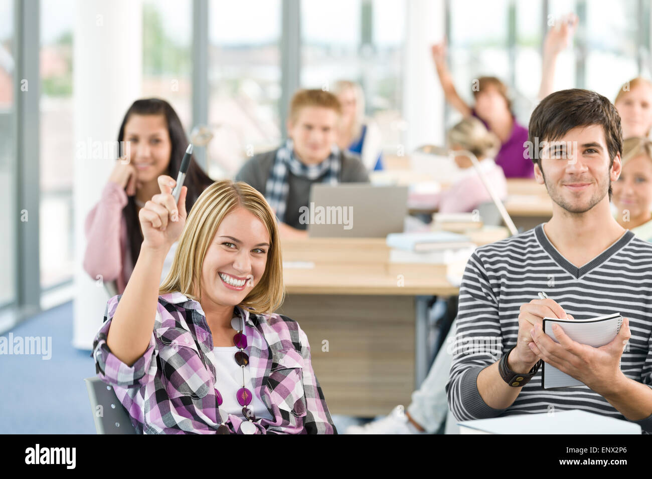 Studente di scuola superiore alzando le mani in aula Foto Stock