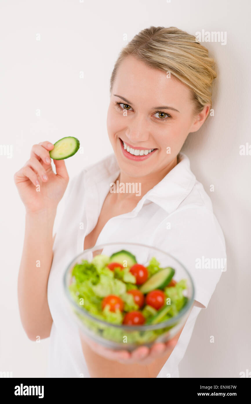 Uno stile di vita sano - Donna sorridente con insalata di verdure Foto Stock