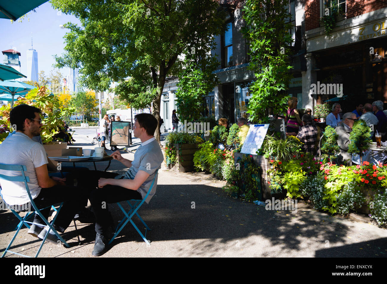 Stati Uniti d'America, nello Stato di New York, New York City, NYC, Ponte di Brooklyn Park, persone mangiare all'aperto a 7 Vecchie Fulton ristorante su tavoli sul marciapiede del vecchio Fulton Street. Foto Stock