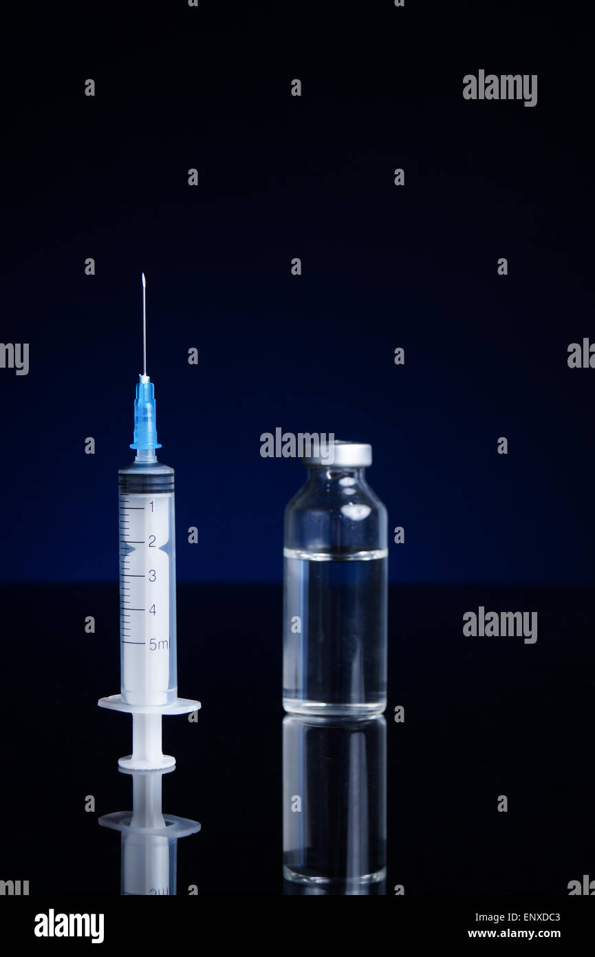 Siringa e fiala medica, con sfondo blu Foto Stock
