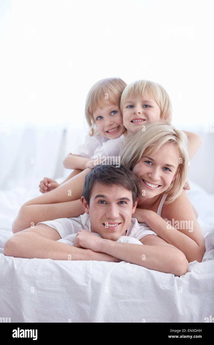 Famiglia in pigiama sul letto in camera da letto Foto Stock