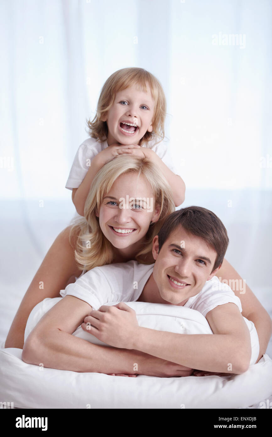 Famiglia attraente in pigiama sul letto Foto Stock