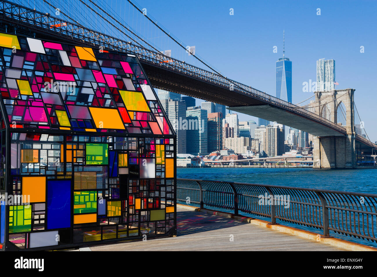 Stati Uniti d'America, nello Stato di New York, New York City, NYC, Ponte di Brooklyn Park, plexiglass colorato casa chiamata Kolonihavehus dallo scultore Tom Fruin al di sotto del ponte che attraversa il fiume est con la parte inferiore di Manhattan Financial District grattacielo skyline al di là. Foto Stock