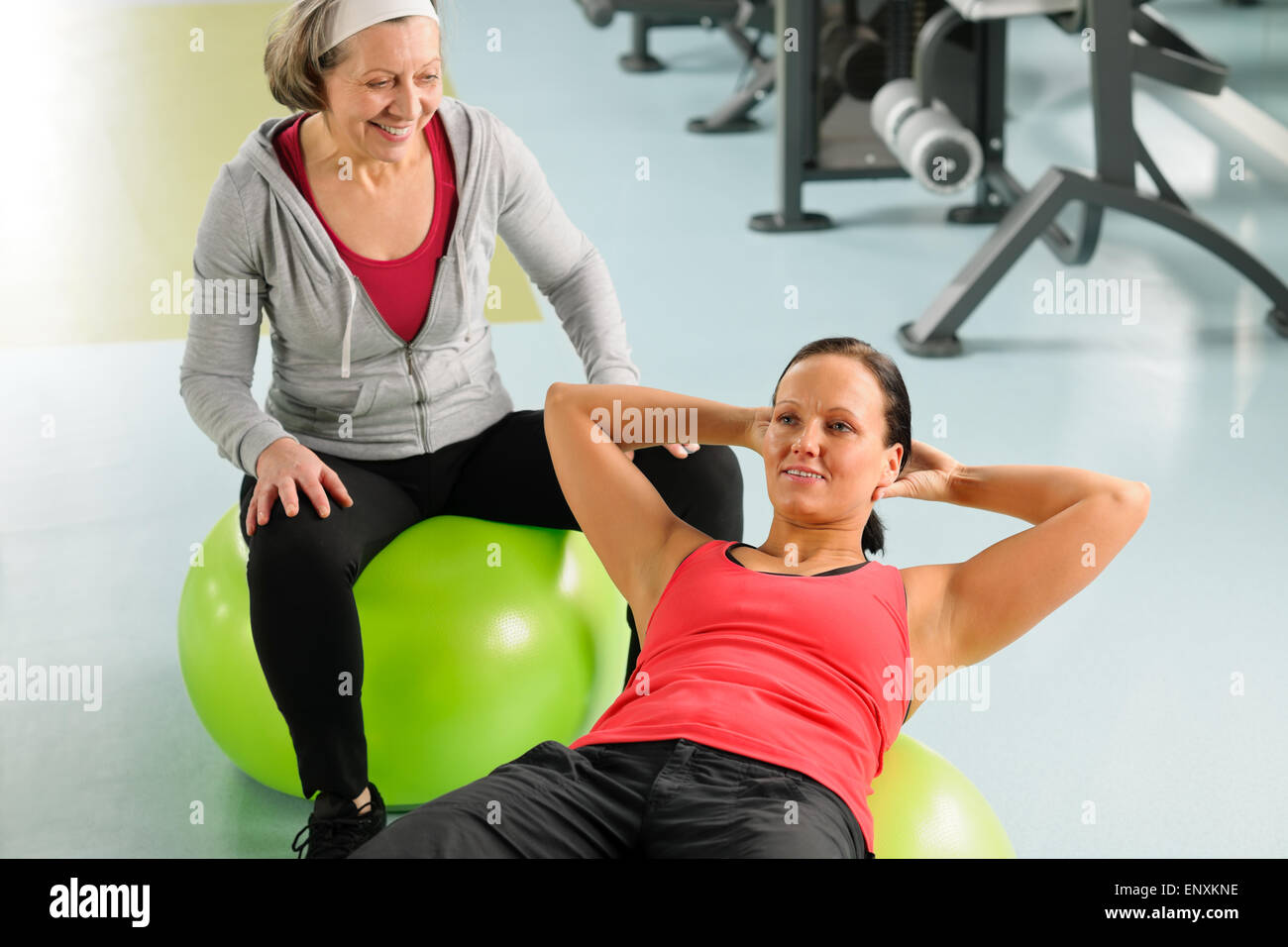 Donna senior con trainer esercizio sfera fitness Foto Stock