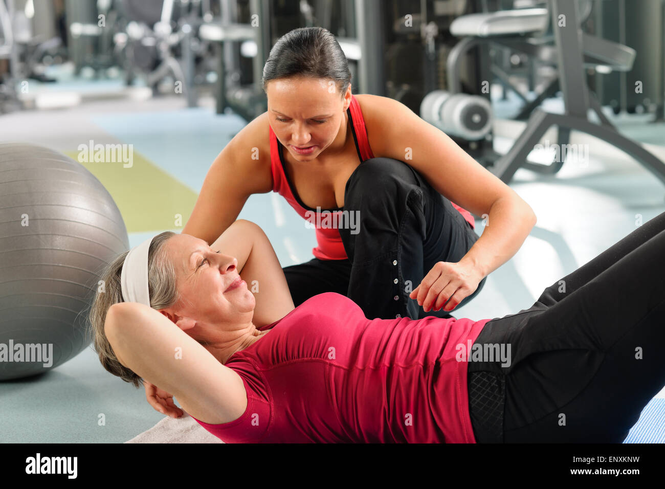 Senior donna addominali esercizio nel centro fitness Foto Stock