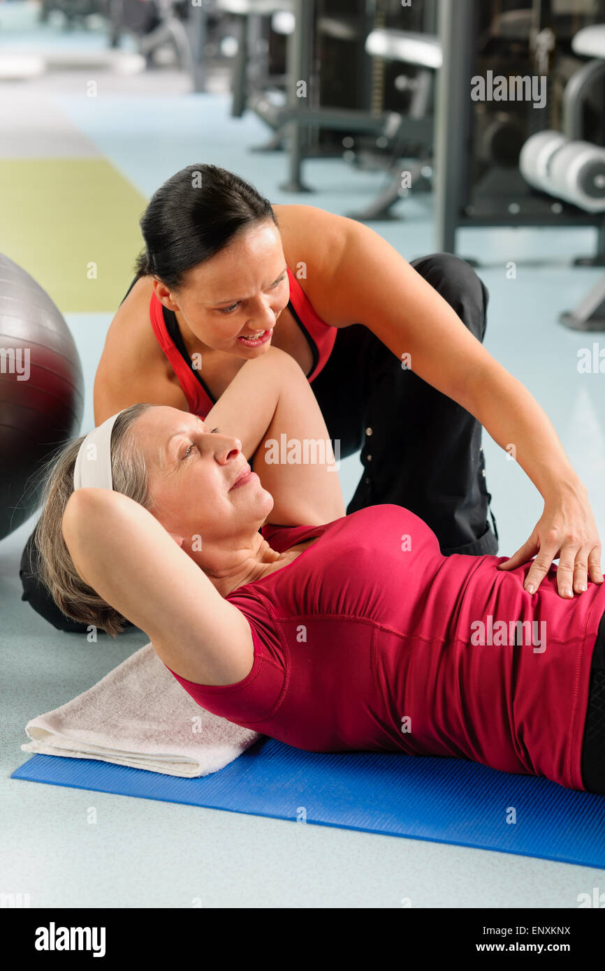 Senior donna addominali esercizio nel centro fitness Foto Stock