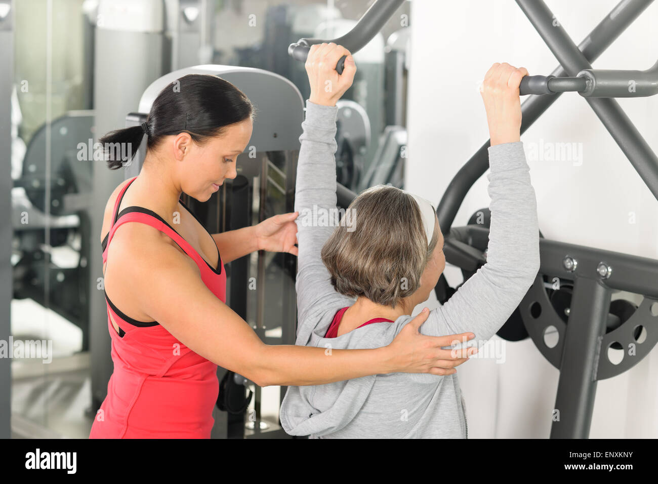 Centro fitness trainer donna senior esercizio spalla Foto Stock