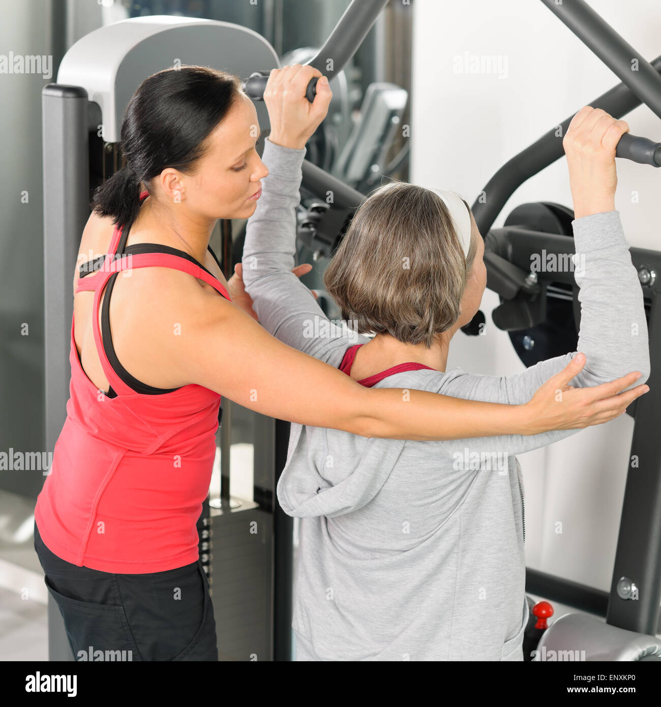 Centro fitness trainer donna senior esercizio indietro Foto Stock