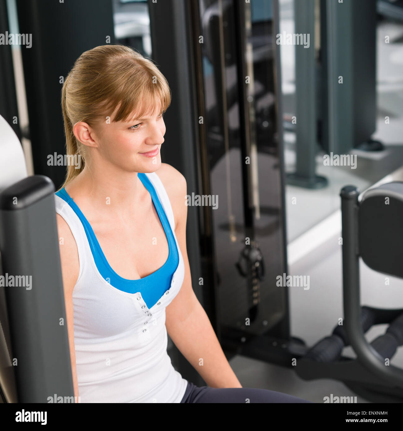 Giovane donna al centro fitness seduta macchina Foto Stock