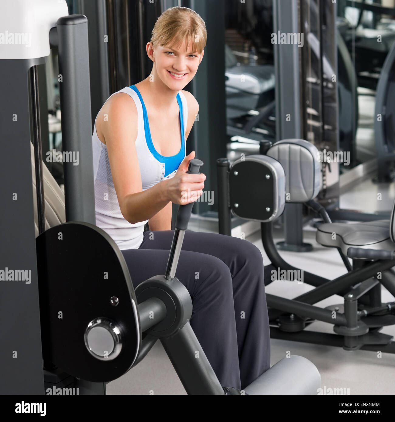 Giovane donna al centro fitness macchina ginnica Foto Stock
