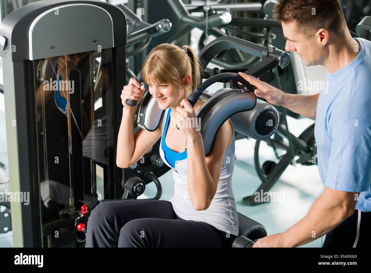 Centro fitness giovane donna esercizio con trainer Foto Stock