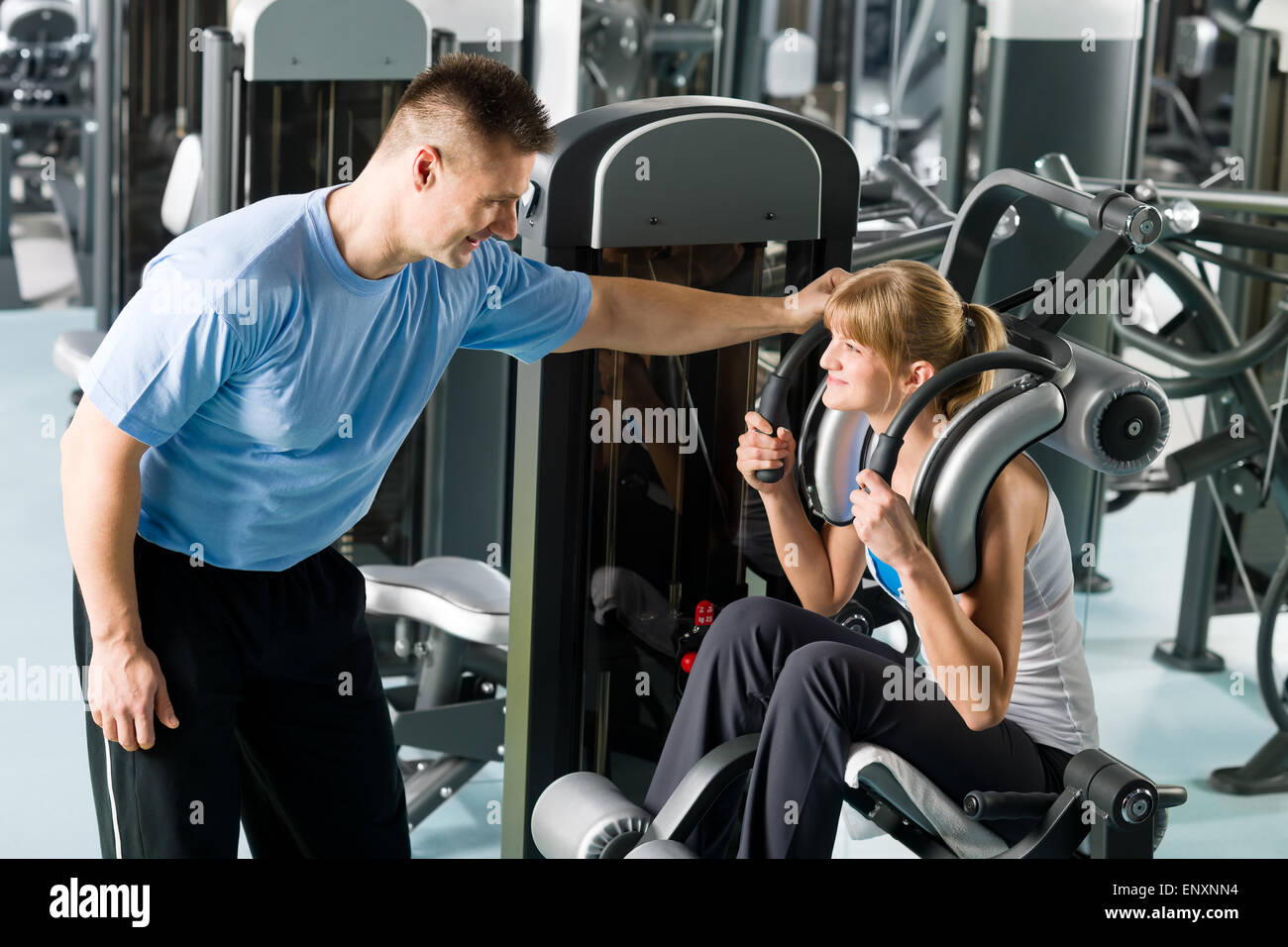 Centro fitness giovane donna esercizio con trainer Foto Stock