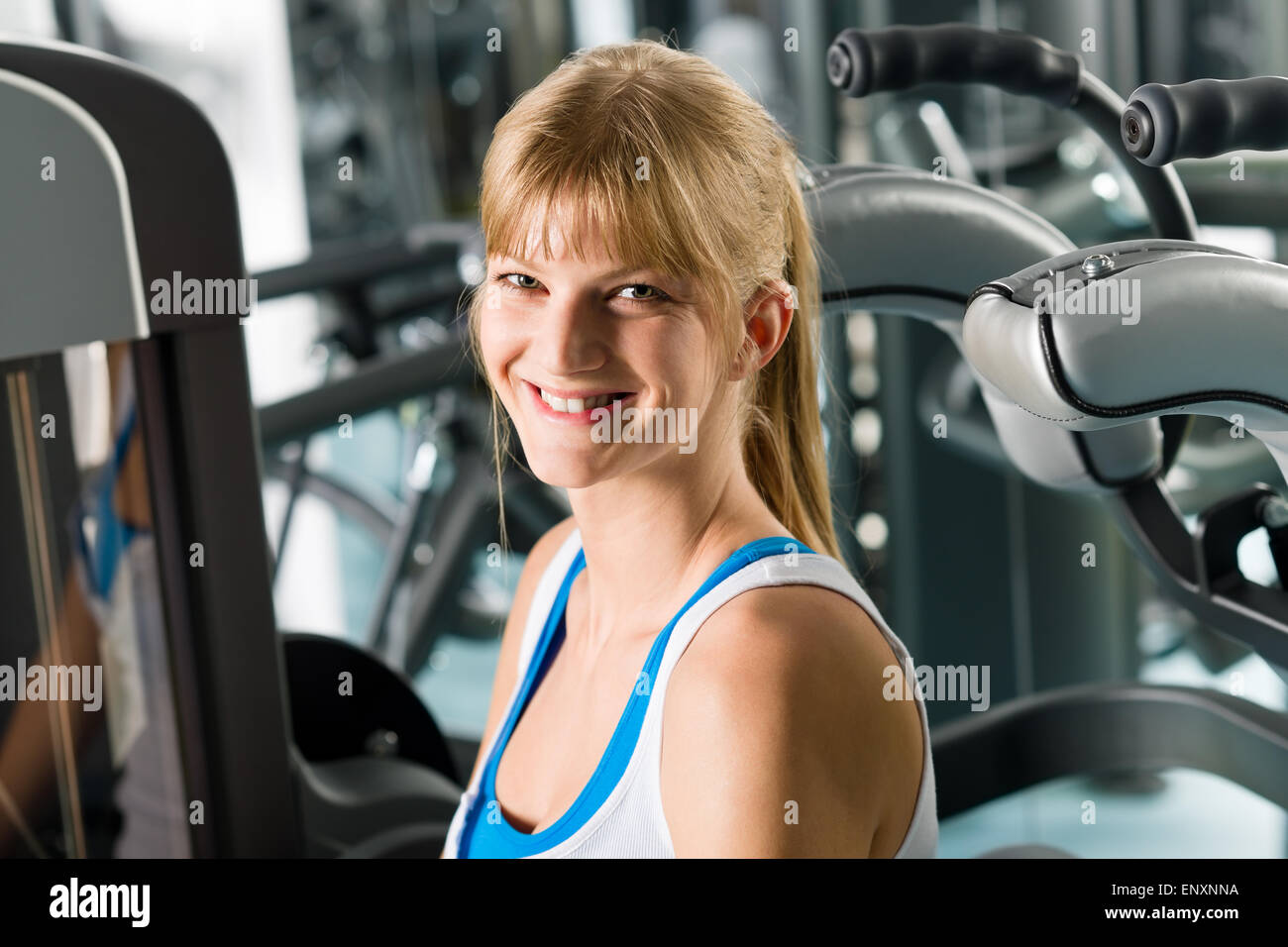 Donna sorridente al centro fitness macchina ginnica Foto Stock