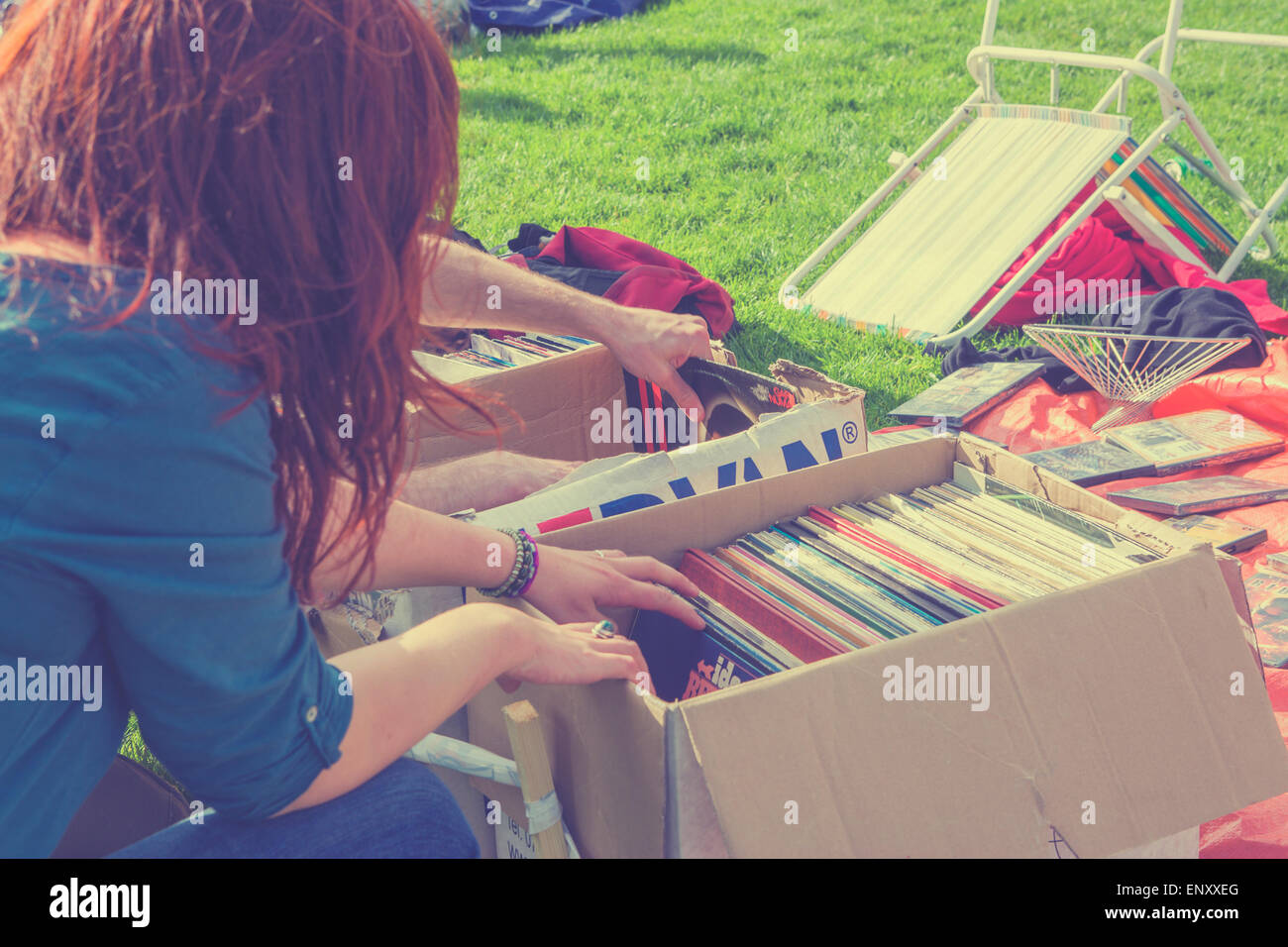 Ragazza di sfogliare di seconda mano gli album in vinile in scatole Foto Stock