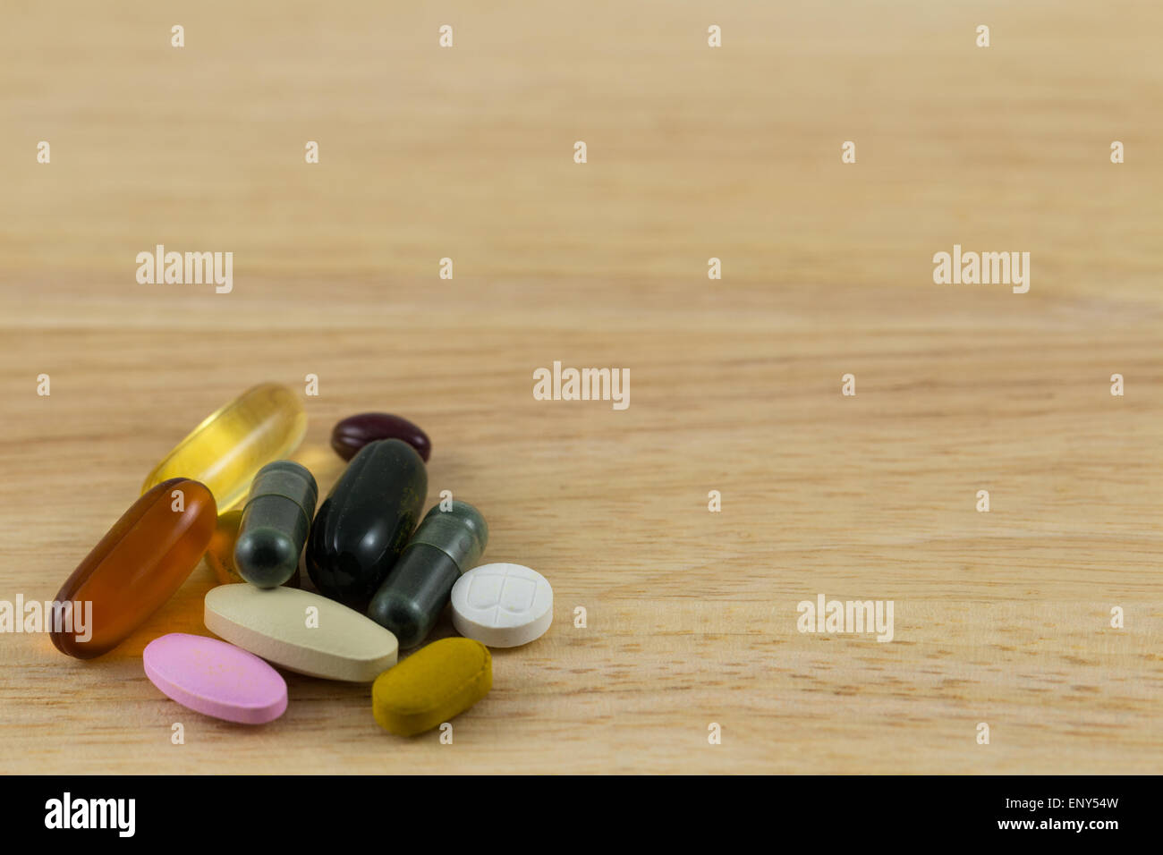 Pills versarsi sul blocco di legno Foto Stock