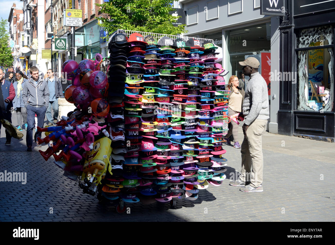 Un venditore ambulante che vende i cappelli da baseball e alcuni giocattoli in Peascod Street, Windsor. Foto Stock